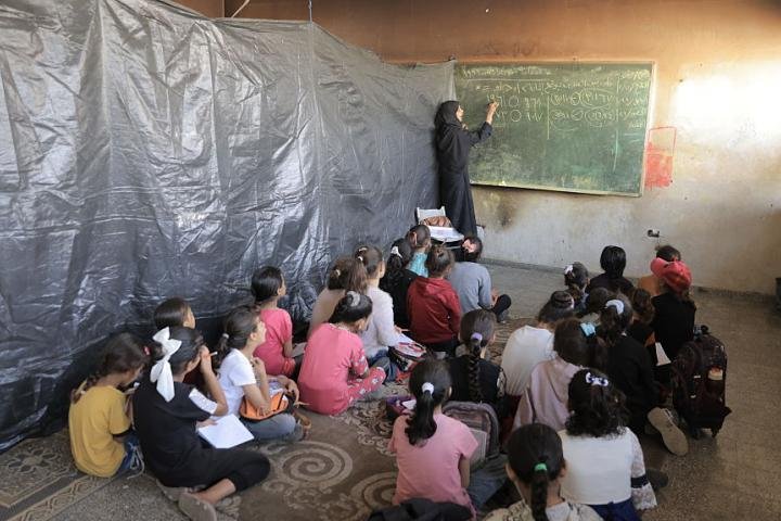 Niños y niñas en un aula improvisada de la escuela secundaria de Beit Lahia, norte de Gaza, atendidos por profesores voluntarios