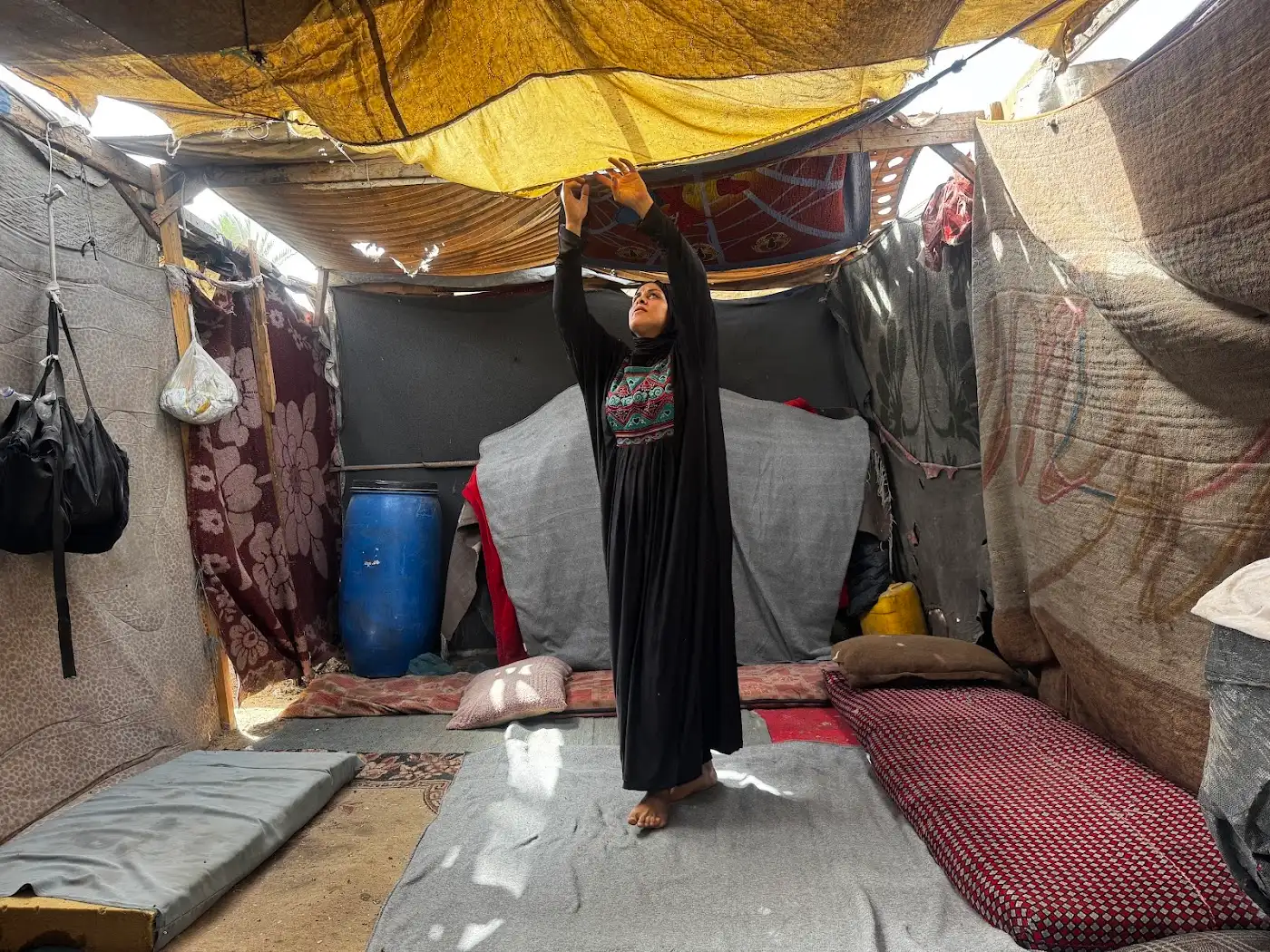 Mujer desplazada en el interior de una tienda deteriorada en Gaza